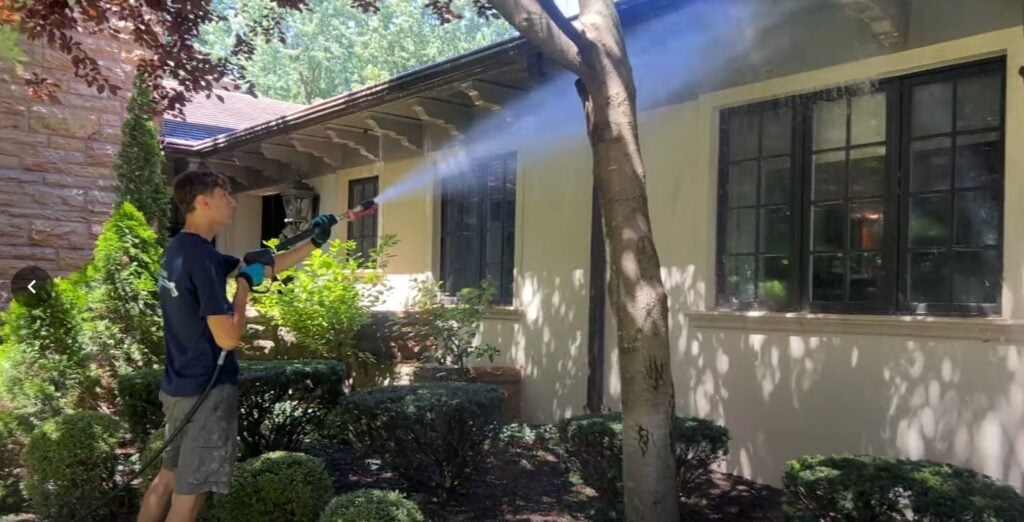 KC Splash technician soft washing the stucco exterior and soffit of a luxury estate in Mission Hills KS