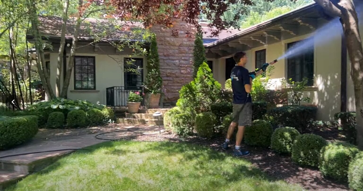 KC Splash soft washing a stone and stucco luxury home with mature landscaping in Mission Hills Kansas City KS