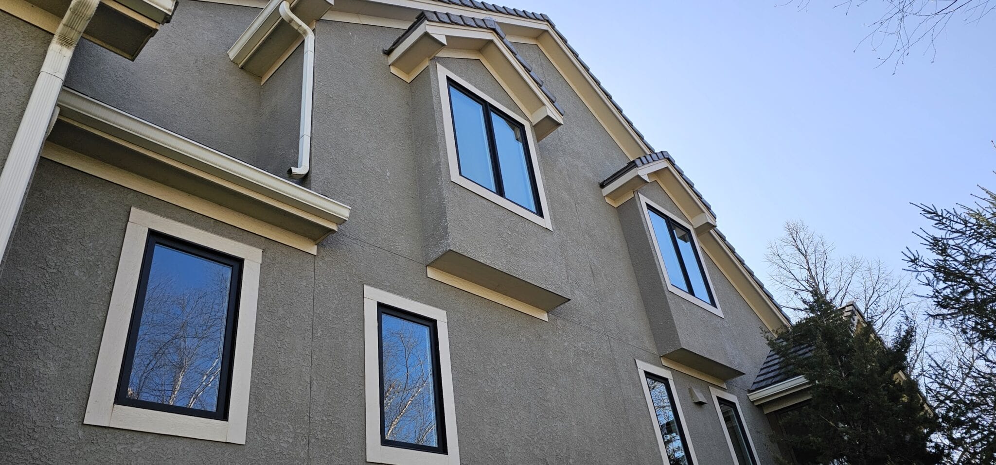 Close up of stucco exterior window trim and tile roofline on a luxury home in Riss Lake Parkville MO