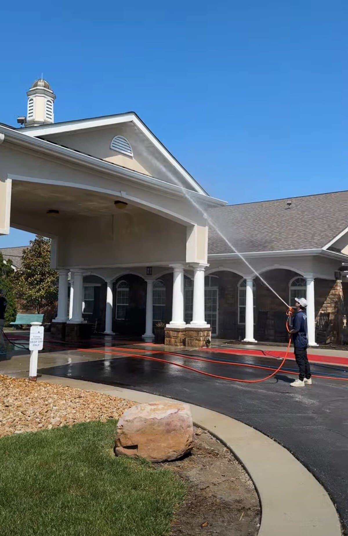 KC Splash crew member soft washing the porte-cochère entry at Addington Place of Shoal Creek Kansas City MO