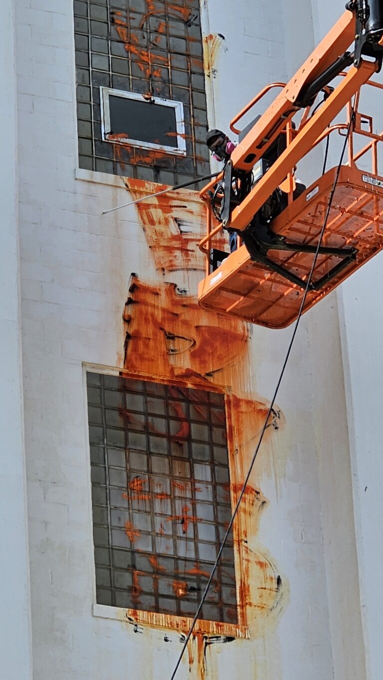 KC Splash boom lift reaching a multi-story wall for graffiti removal