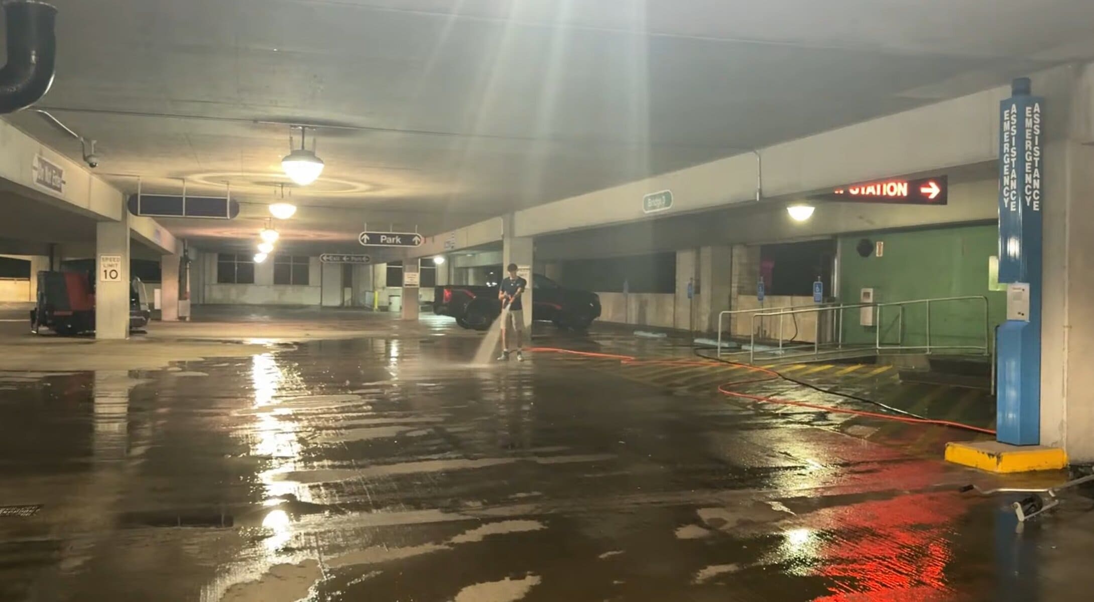 KC Splash technician pressure washing around Pay Station and Emergency Assistance area at K-State garage overnight
