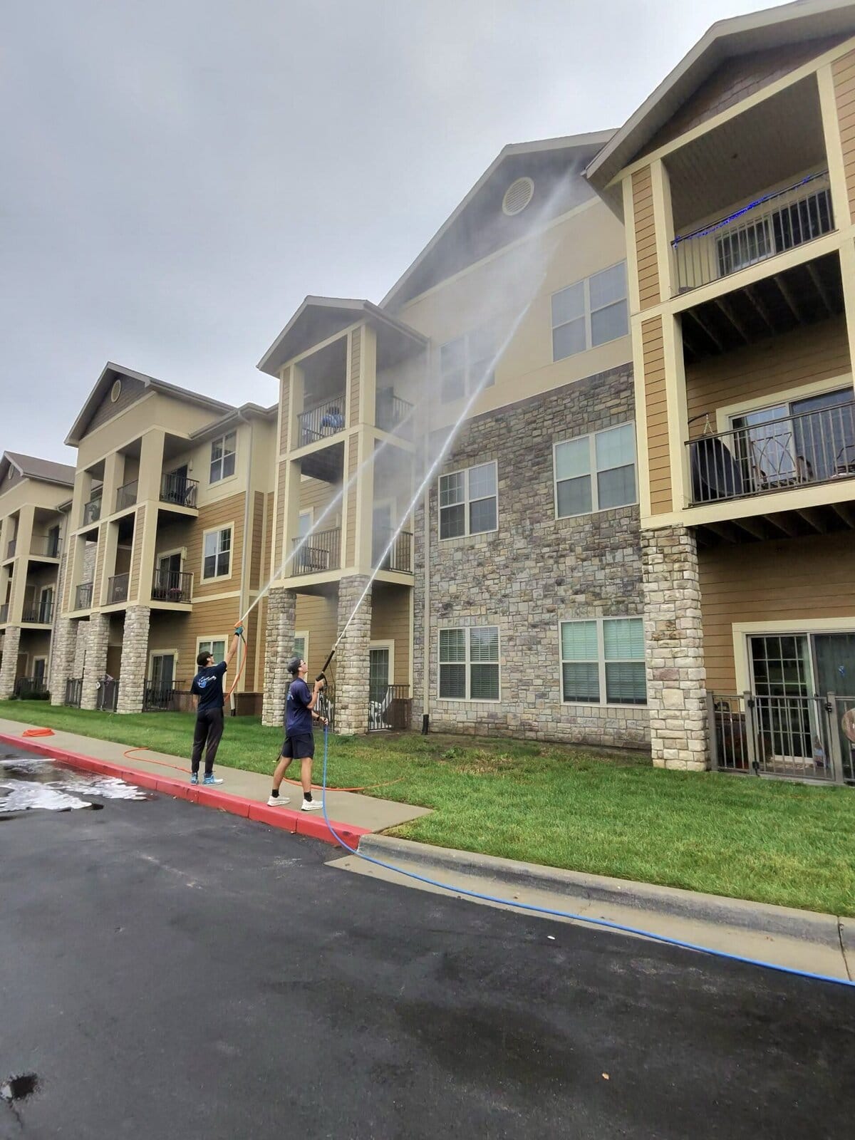 KC Splash crew member soft washing upper floors of senior living building