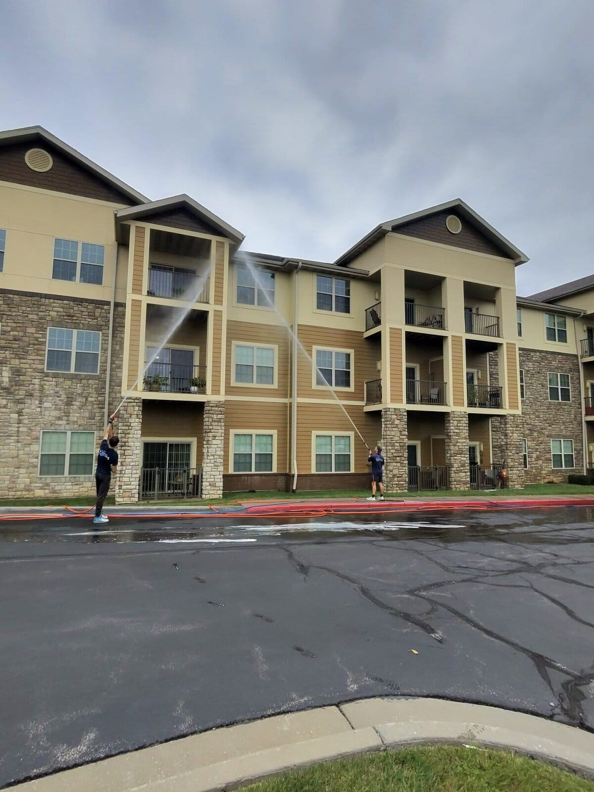 KC Splash crew applying soft wash solution to building exterior at Parkway Senior Living
