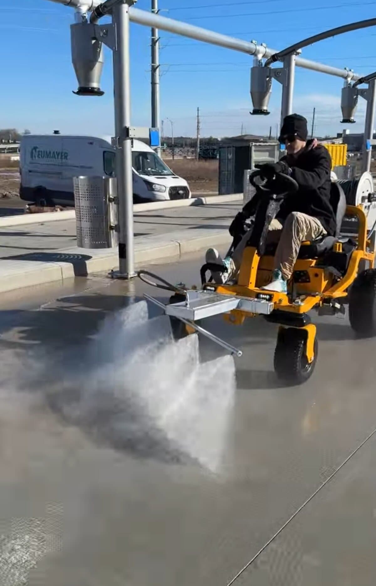 Close-up of The Beast surface cleaner steam blast under Tidal Wave Auto Spa car wash canopy