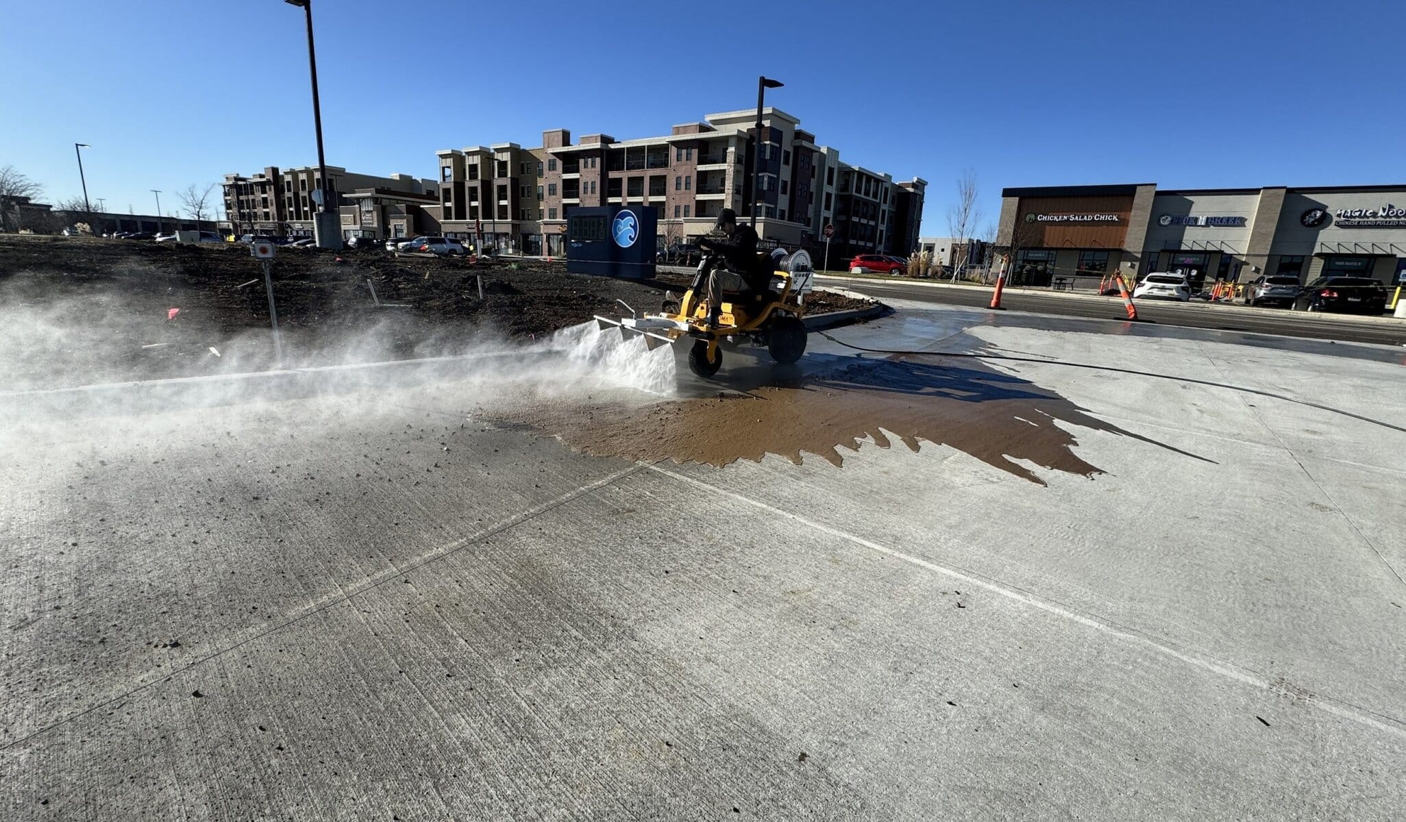 The Beast full spray arc across Tidal Wave Auto Spa parking lot