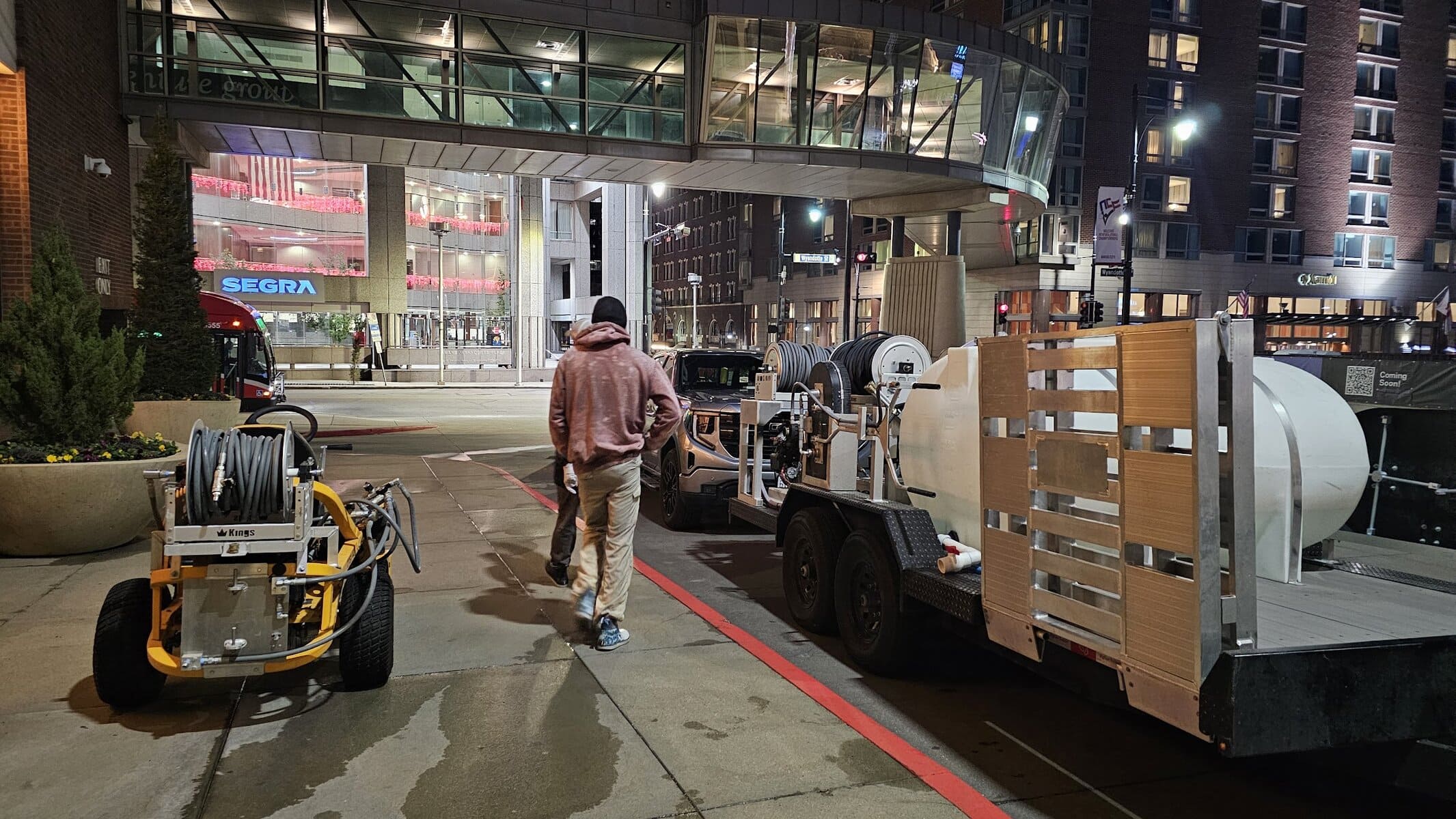 KC Splash Kings surface cleaner and Bigfoot trailer staged outside Kansas City Marriott Downtown at night with downtown skybridge and Segra Arena in background