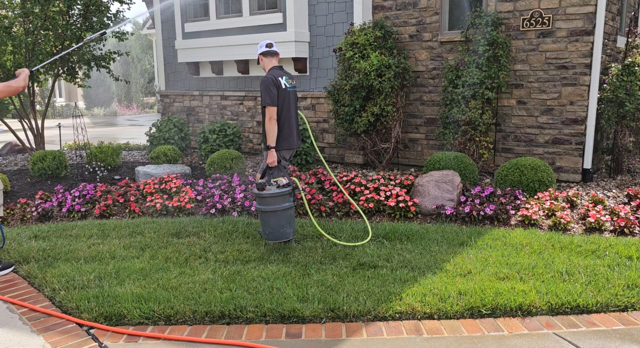 KC Splash technician applying plant protection to the flower beds before a house wash in Kansas City