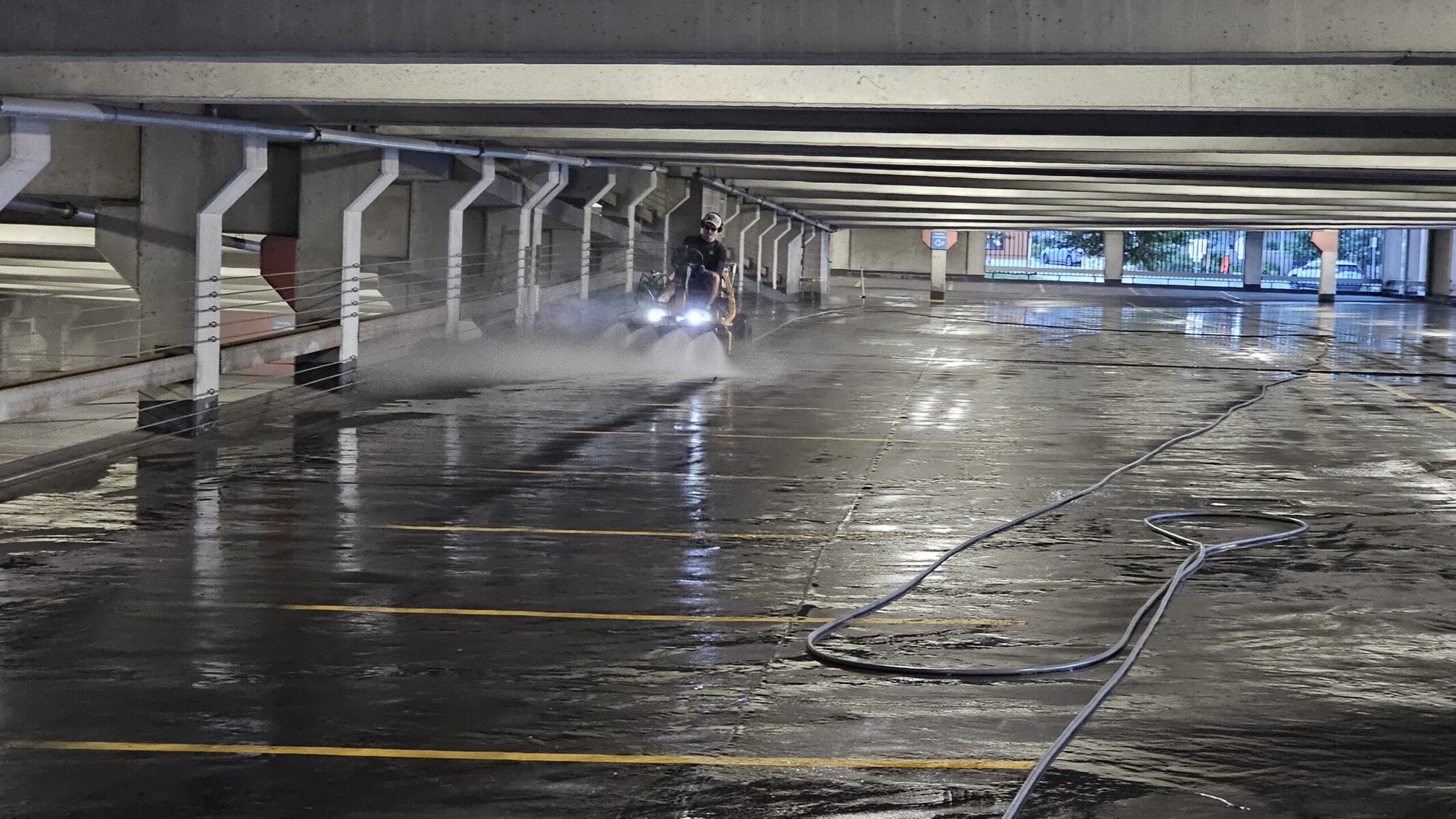 The Beast ride-on surface cleaner laying down a high-flow pass at Crown Center garage Kansas City