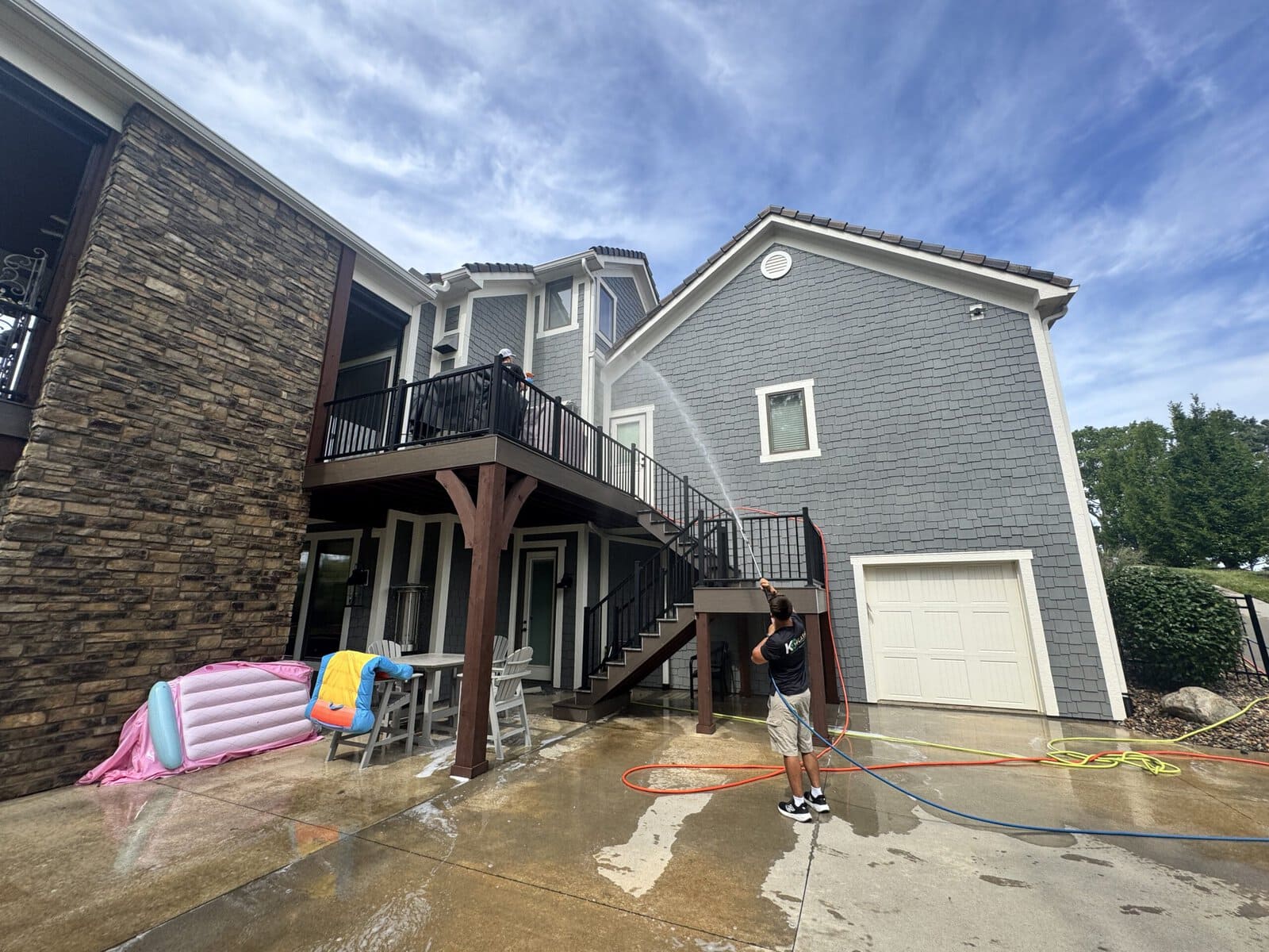 KC Splash technician soft washing painted shingle siding on a Northland luxury estate