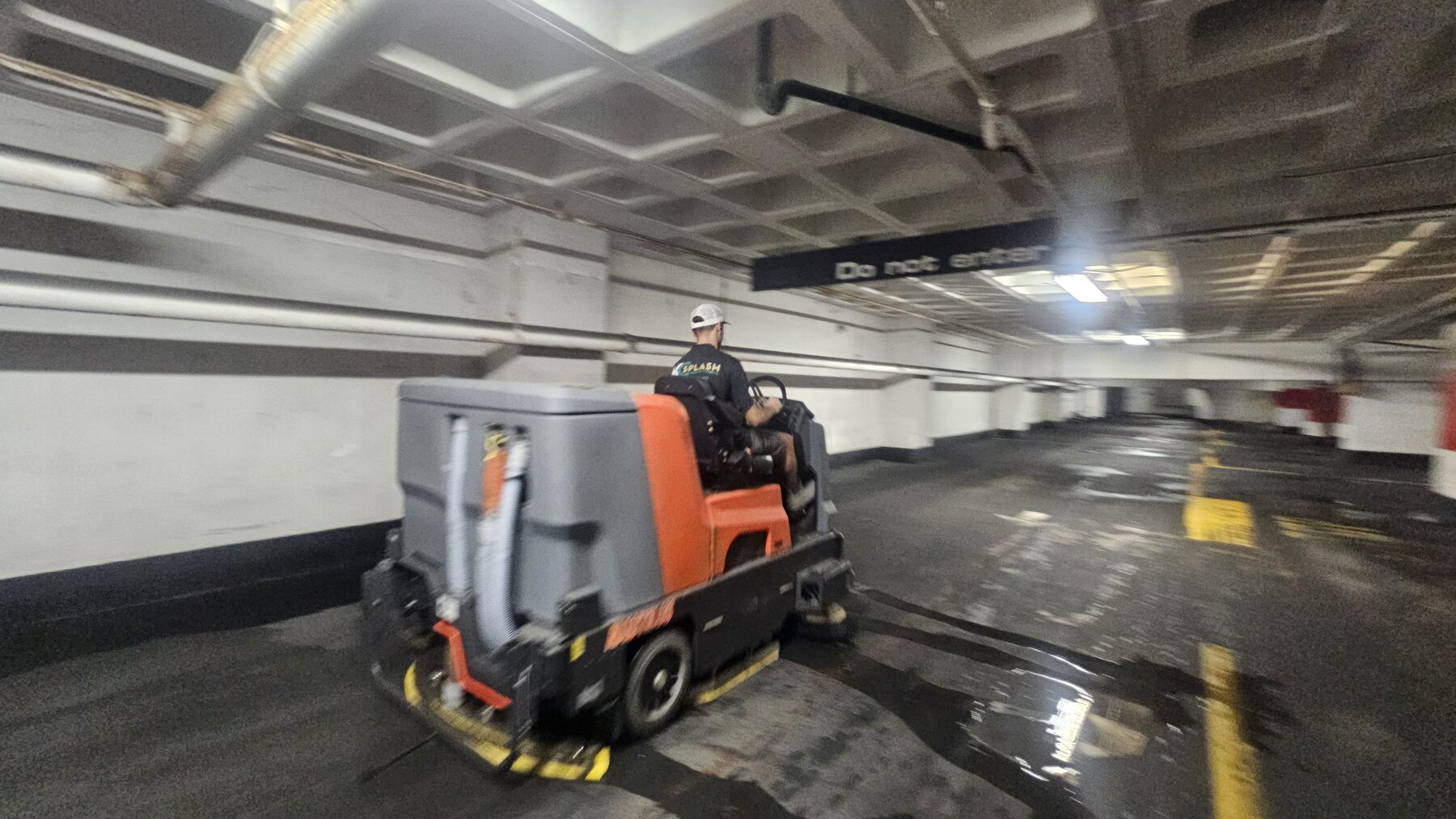Ride-on floor scrubber extracting wash water in the Lightwell parking garage