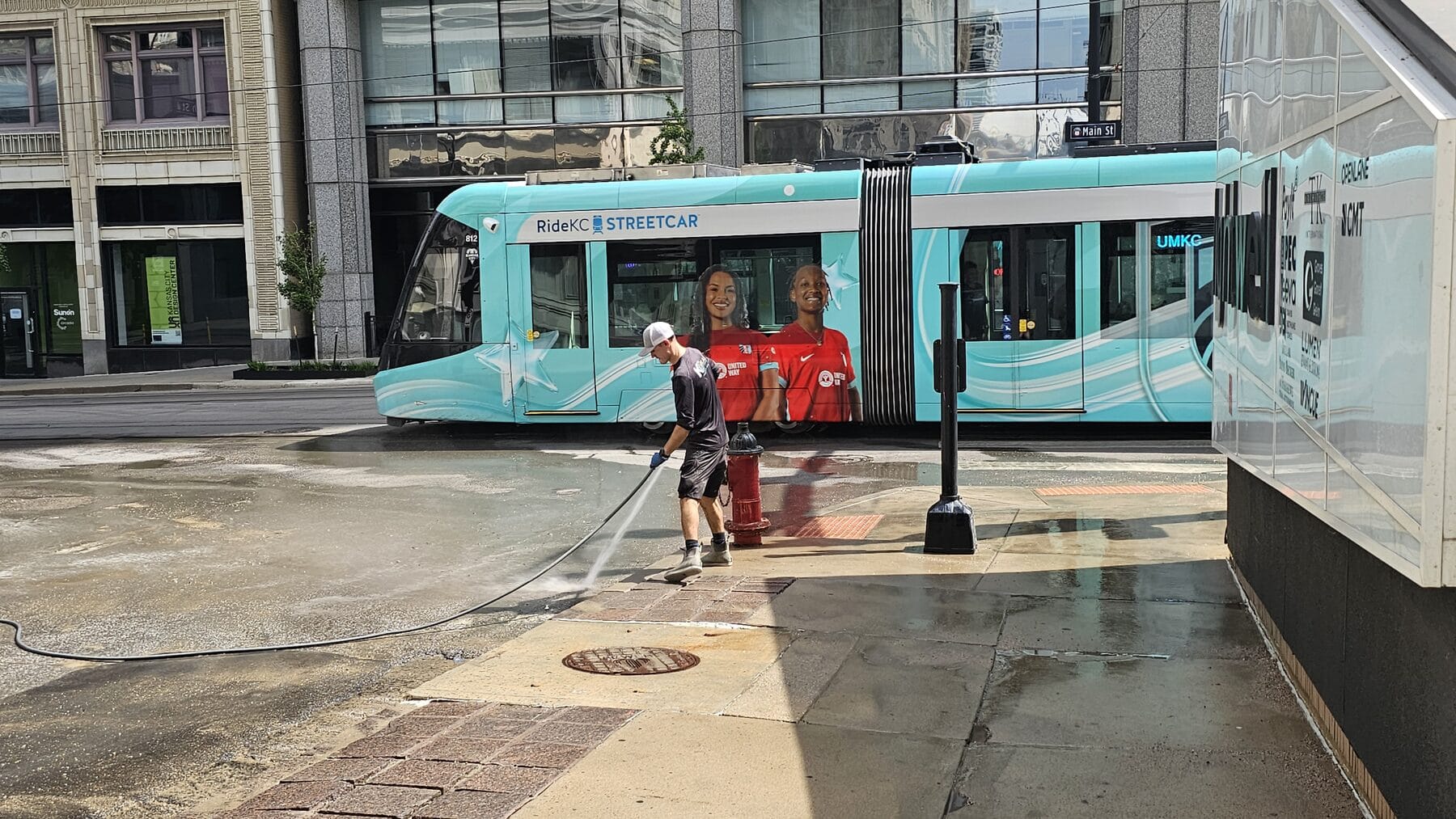 KC Splash crew washing the public street outside the Lightwell as the KC Streetcar passes